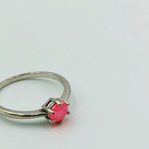 May include: A silver ring with a pink opal gemstone.