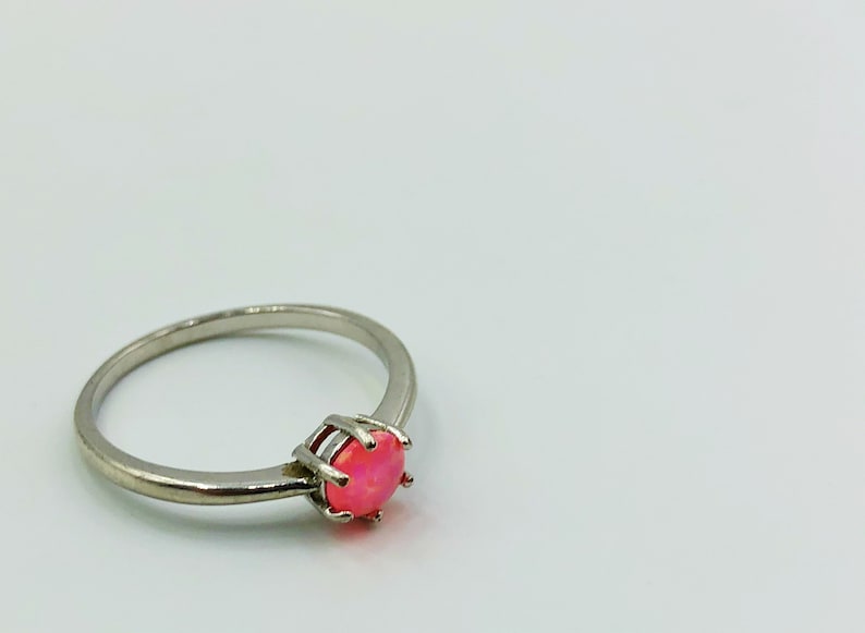 May include: A silver ring with a pink opal gemstone.