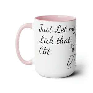 May include: White ceramic mug with a pink interior and handle. The mug features the text "Just Let me Lick that Clit" in black script, along with a line drawing of a person.