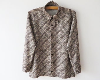 May include: A button-down shirt with a brown and beige diagonal striped pattern. The long-sleeved shirt has a collared neckline and is hanging on a wooden hanger. The shirt has dark brown buttons.