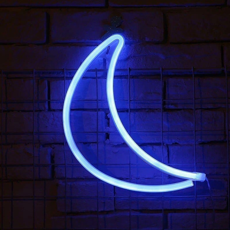 May include: A blue neon crescent moon light fixture on a brick wall.