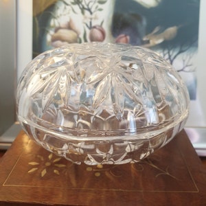 May include: A clear glass lidded dish with a cut glass design. The dish is round and has a domed lid.
