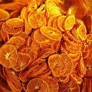 May include: A bowl filled with dried orange slices. The slices are arranged in a random pattern and are a vibrant orange color.