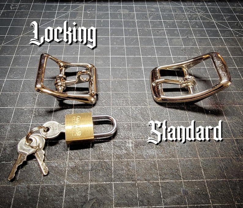 K&ouml;nnte beinhalten: Zwei silberne G&uuml;rtelschnallen aus Metall, eine mit der Aufschrift "Locking" und die andere mit der Aufschrift "Standard". Ein Messingvorh&auml;ngeschloss mit zwei Schl&uuml;sseln ist ebenfalls abgebildet.