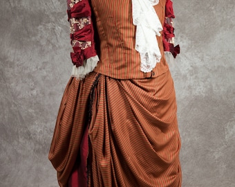 May include: A brown and red striped dress with a white lace collar and red sleeves. The dress is gathered at the waist and has a long, flowing skirt.