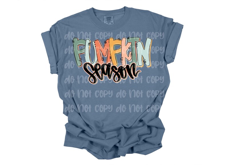 Peut inclure: Un t-shirt bleu avec l'inscription "PUMPKIN SEASON" dans une typographie color&eacute;e et ludique. Le texte est en orange, vert et noir, cr&eacute;ant un th&egrave;me automnal festif. Le t-shirt a des manches courtes et une coupe d&eacute;contract&eacute;e.