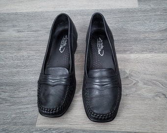 May include: A pair of black leather loafers with a stitched detail around the toe. The shoes have a comfortable fit and are designed for everyday wear.