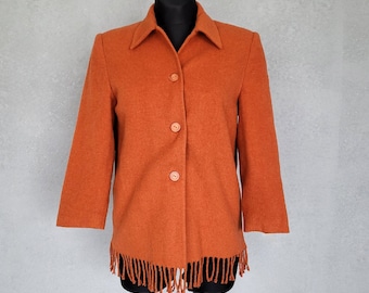 Könnte beinhalten: Eine langärmelige, knopfverschluss-Jacke in verbranntem Orange mit Fransen am Saum.