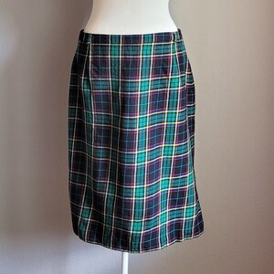 May include: A green, black, yellow and pink plaid skirt. The skirt is knee-length and has a straight silhouette.