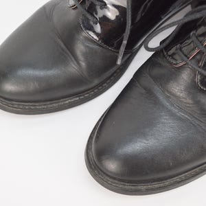 Puede incluir: Un par de zapatos negros de cuero con cordones y puntera de charol.