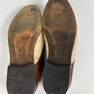 May include: Pair of used brown and tan leather shoes, with a canvas upper and a brown leather toe cap. The soles are worn, showing signs of use. The size is marked as 38.