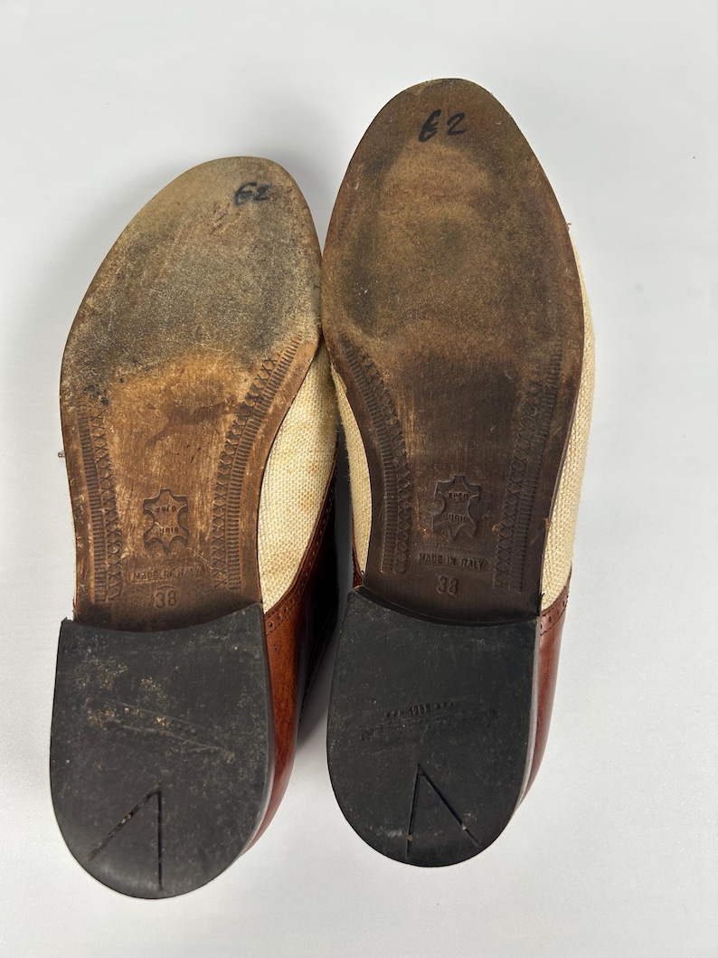 May include: Pair of used brown and tan leather shoes, with a canvas upper and a brown leather toe cap. The soles are worn, showing signs of use. The size is marked as 38.