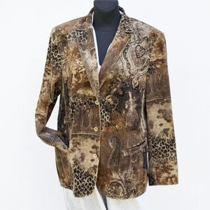 Può includere: Un blazer marrone con un motivo paisley multicolore e stampa animalier. Il blazer ha una chiusura con un solo bottone e due tasche.