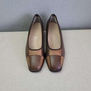 May include: A pair of brown leather shoes with a square toe. The shoes have a patchwork design with different shades of brown leather. The shoes are size 7 1/2.