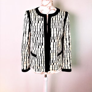 Op de afbeelding: Een zwart-wit geblokt blazer met zwarte bies. De blazer is op een witte mannequin.