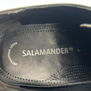 K&ouml;nnte beinhalten: Nahaufnahme des Inneren eines schwarzen Lederschuhs. Die Innensohle tr&auml;gt den Markennamen "SALAMANDER" in wei&szlig;en Buchstaben. Die Schuhgr&ouml;&szlig;e ist mit "8" angegeben. Die Worte "OBERMATERIAL LEDER" sind ebenfalls sichtbar.