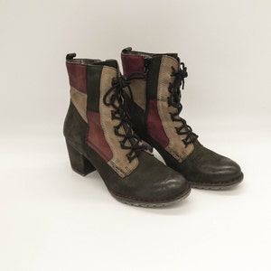 May include: A pair of brown, green, and red leather ankle boots with laces. The boots have a chunky heel and a rounded toe.