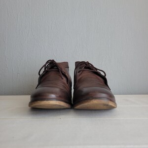 May include: A pair of brown leather lace-up shoes with a slightly rounded toe.