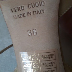 May include: Close-up of the bottom of a beige shoe with the text "Vero Cuoio Made in Italy" and the size "38". A label with the text "Leather Upper Leather Lining Leather Sole Made in Italy" is visible.