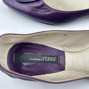 Op de afbeelding: Een paar paarse leren ballerina's. De schoenen hebben een donkerpaars accent op de bovenkant en een label aan de binnenkant met de tekst "Gianfranco Ferr&eacute;". De maat is 36.