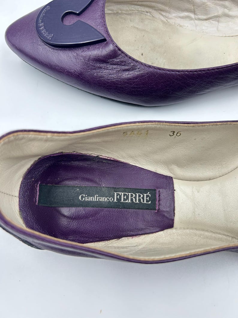 Op de afbeelding: Een paar paarse leren ballerina's. De schoenen hebben een donkerpaars accent op de bovenkant en een label aan de binnenkant met de tekst "Gianfranco Ferr&eacute;". De maat is 36.