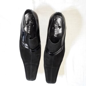 Puede incluir: Un par de zapatos de ante negro con ribete de charol negro. Los zapatos tienen punta puntiaguda y tac&oacute;n bajo. El nombre de la marca "Runway" est&aacute; impreso en el interior de cada zapato.