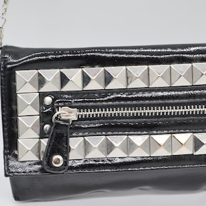 Cartera de piel de charol con tachuelas en color negro y correa de cadena / Bolso bandolera con solapa y botón a presión para mujer / Gina Tricot