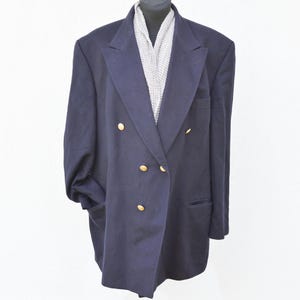 Könnte beinhalten: Ein dunkelblauer zweireihiger Blazer mit goldenen Knöpfen.