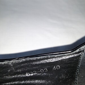 Puede incluir: Primer plano del interior de un zapato negro con la talla 40 y el n&uacute;mero 832-03 impreso en la plantilla.