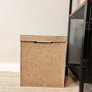 High laundry bin with lid And wooden handles.