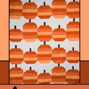 May include: A quilted wall hanging featuring a repeating pattern of orange and light orange pumpkins with black stems. The words "Pumpkin Parade" are at the top, and the designer's name and company are at the bottom.