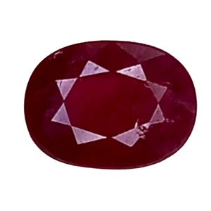 Puede incluir: Gema de rubí de forma ovalada con un tono rojo intenso. La gema presenta un patrón en forma de estrella en el centro, creado por la reflexión de la luz en las facetas. El rubí se encuentra sobre un fondo blanco.