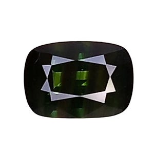 Puede incluir: Una piedra preciosa de color verde oscuro con talla cojín, que presenta una superficie facetada que crea un patrón de reflexión distintivo en forma de estrella en el centro. La piedra tiene un tono verde bosque profundo y saturado.