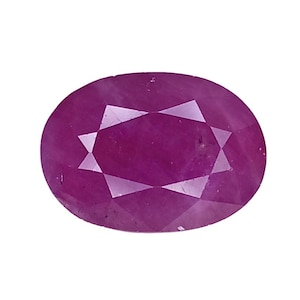 Puede incluir: Una piedra preciosa de corte ovalado con un tono magenta rosado intenso. La piedra presenta una superficie facetada con un patrón simétrico de facetas triangulares y en forma de cometa que reflejan la luz, creando un aspecto pulido y brillante.