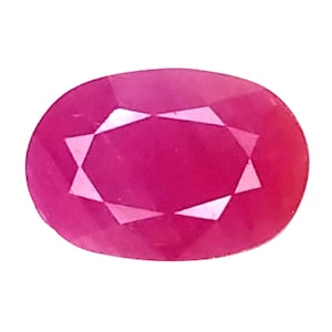 Może przedstawiać: Owalny rubin z fasetami. Kamień szlachetny w odcieniu różowo-czerwonym, z wewnętrznymi fasetami tworzącymi wzór gwiazdy. Kamień osadzony na białym tle. Piękna biżuteria.