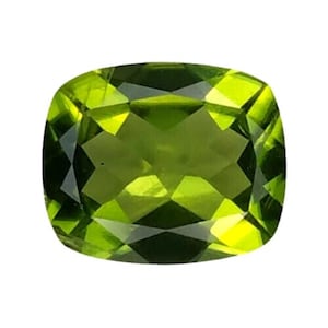 Puede incluir: Una gema de peridoto con talla cojín, de un vibrante tono verde claro. La gema está facetada, mostrando su estructura interna y brillo. La forma es un cuadrado redondeado, ideal para joyería.