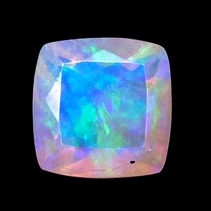 May include: A cushion-cut opal gemstone featuring a vibrant play-of-color with dominant flashes of electric blue and emerald green against a translucent, milky white base. The faceted surface reflects light, creating a shimmering effect.