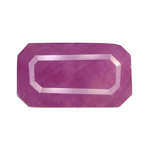 Puede incluir: Una gema rectangular facetada con un tono rosa-púrpura. La gema presenta una incrustación rectangular de color más claro, creando un efecto enmarcado. Los bordes de la piedra están cortados con precisión, mostrando su claridad y forma.