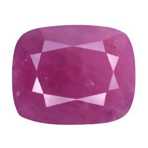 May include: A cushion-cut gemstone with a vibrant magenta-pink hue. The stone features a faceted surface that creates a symmetrical geometric pattern of light and dark reflections across its polished, translucent, and rounded square-shaped body.
