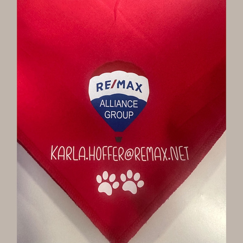 May include: Red triangular bandana with a white hot air balloon graphic featuring the text "RE/MAX ALLIANCE GROUP" and the text "KARLA.HOFFER@REMAX.NET". Two white paw prints are below the text.