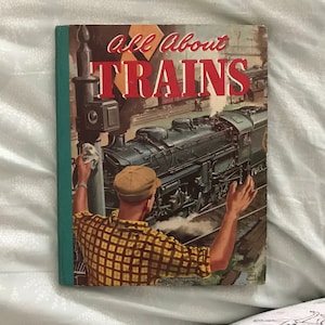 May include: A vintage book titled "All About Trains" with a green spine and a colorful illustration of a train and a man on the cover.