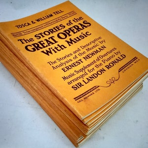 Może przedstawiać: Stos żółtych książek w miękkiej oprawie zatytułowany "The Stories of the Great Operas with Music". Okładka książki zawiera tytuł w pogrubionym czarnym kolorze i zawiera nazwiska autorów Ernsta Newmana i Sir Landona Ronalda.