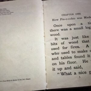 May include: Open book with text from the story "Pinocchio". The text reads "How Pin-occhio was Made" and "Once upon a time there was a small log of wood."