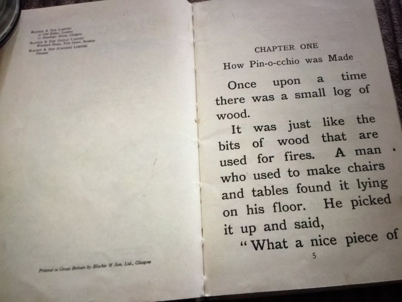 May include: Open book with text from the story "Pinocchio". The text reads "How Pin-occhio was Made" and "Once upon a time there was a small log of wood."
