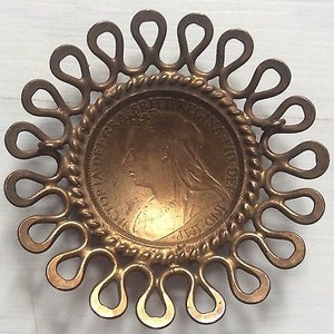 Original 1896 coin hammered into a domed shape within an ornate copper mount - lugs to back.