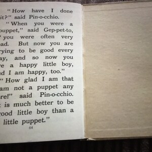 May include: Open book pages with text from a children's story. The left page displays text from the story, including dialogue. The right page is blank. The text includes the words "Pin-o-cchio" and "puppet".