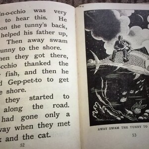 May include: An open book with text and an illustration. The left page has text from a story about Pinocchio. The right page shows a black and white illustration of a person riding a fish underwater. Text at the bottom reads "AWAY SWAM THE TUNNY TO THE SHORE."