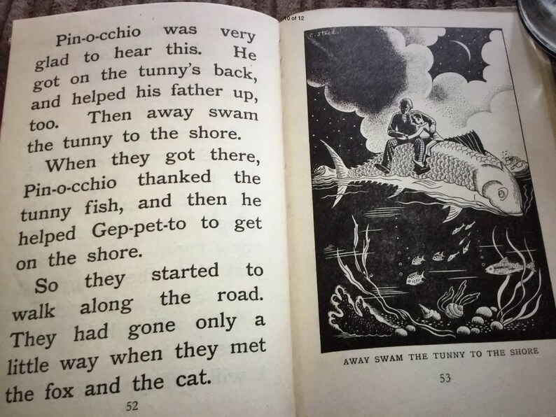 May include: An open book with text and an illustration. The left page has text from a story about Pinocchio. The right page shows a black and white illustration of a person riding a fish underwater. Text at the bottom reads "AWAY SWAM THE TUNNY TO THE SHORE."