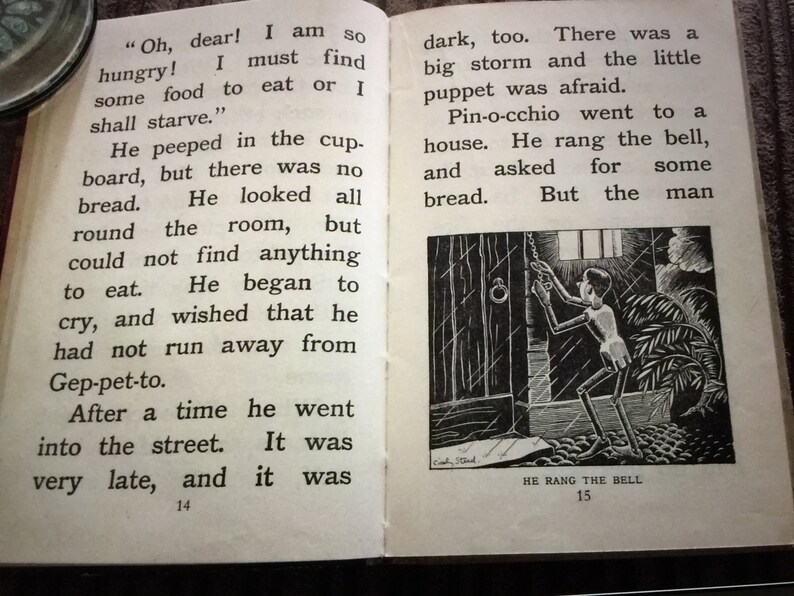 May include: Open book with text and an illustration. The text reads, "Oh, dear! I am so hungry! I must find some food to eat or I shall starve." The illustration shows a puppet ringing a bell. The text below the illustration reads, "HE RANG THE BELL."