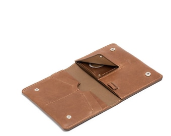May include: A brown leather wallet with multiple pockets and a snap closure. The wallet is open and the interior is visible.
